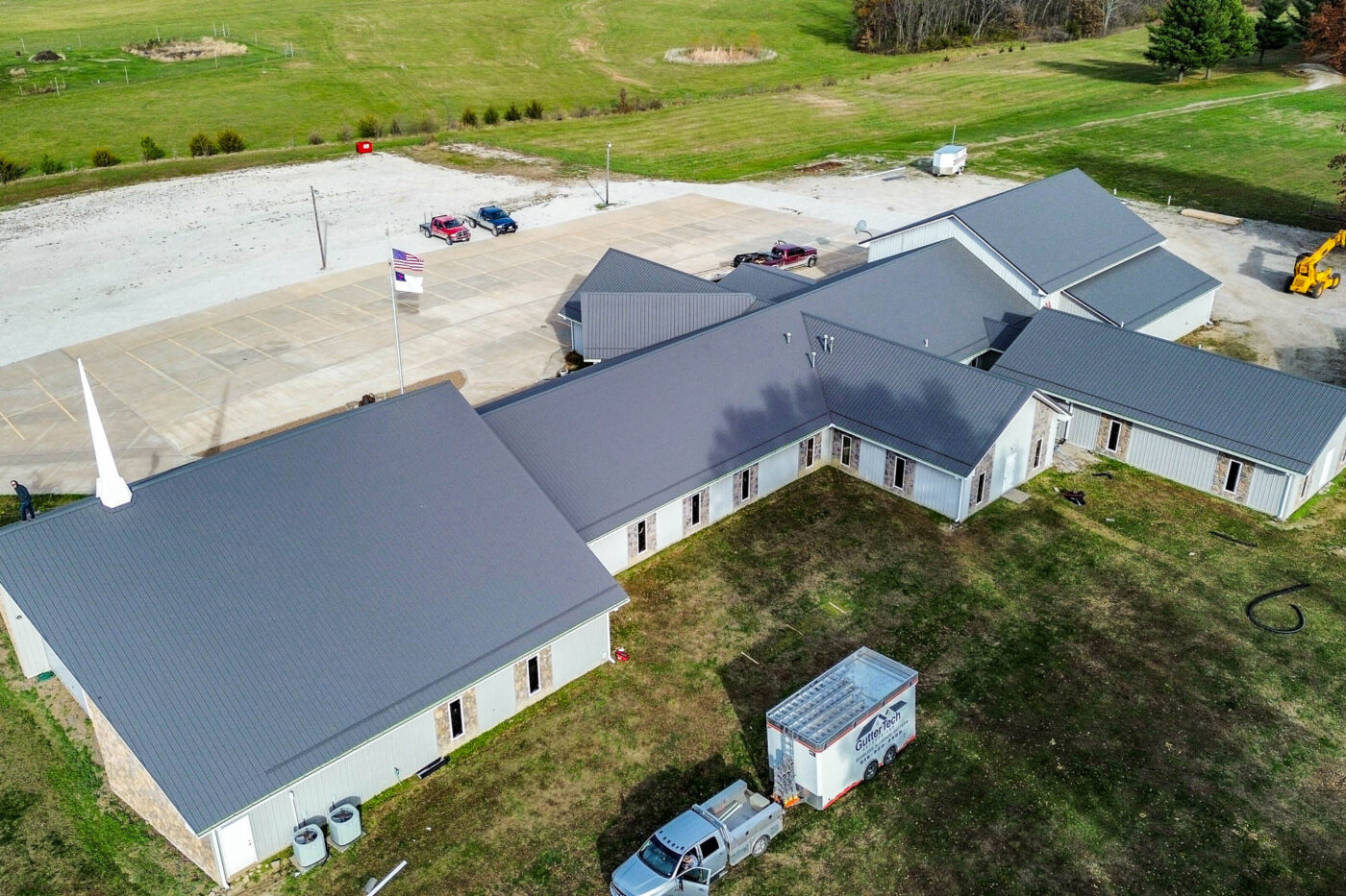 Overhead aerial image of a large church complex with multiple rooflines and freshly installed gutters surrounding the entire perimeter of the structure.