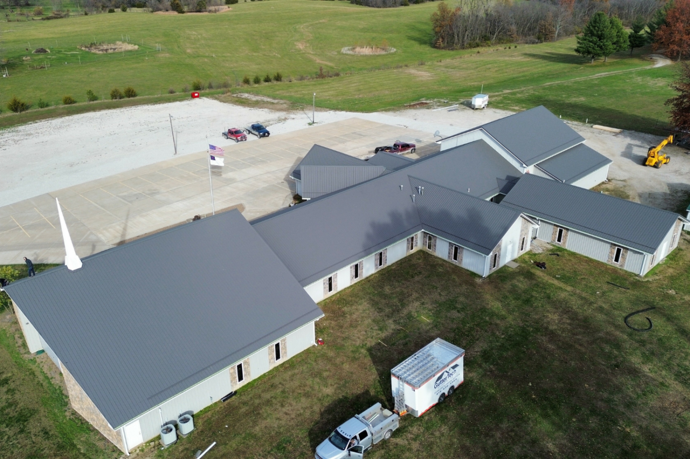 back side of gray and white building with new gutters