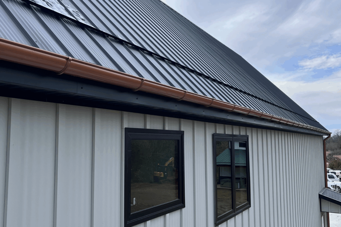 gutter on the side of a white building with a black roof in platte city mo